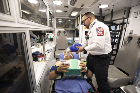 an ems working on patient in back of ambulance